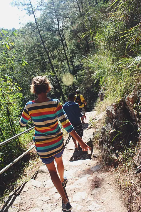 Stef y Luis descendiendo en el sendero hacia la boca de la cueva Lumiang.