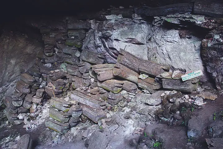 Varios ataúdes de piedra y de madera apilados unos sobre los otros. Han estado allí por al menos 65 años.