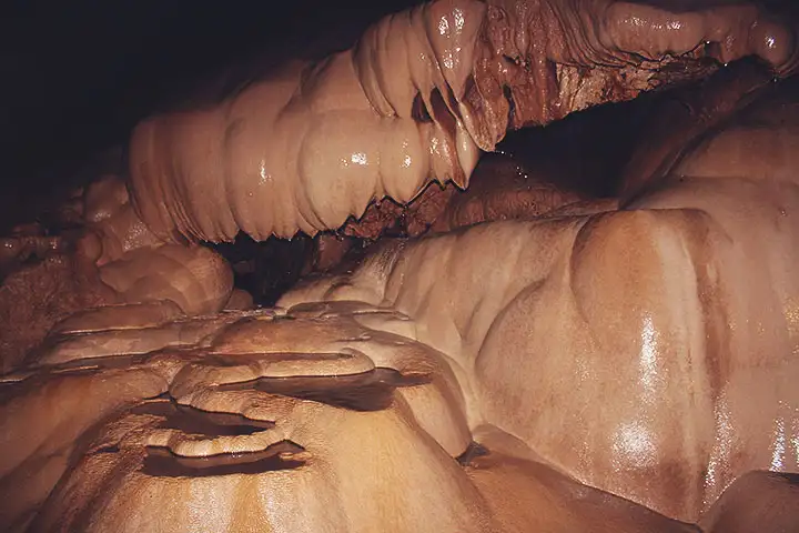 Formaciones de piedra lisa y posos naturales dentro de la cueva.