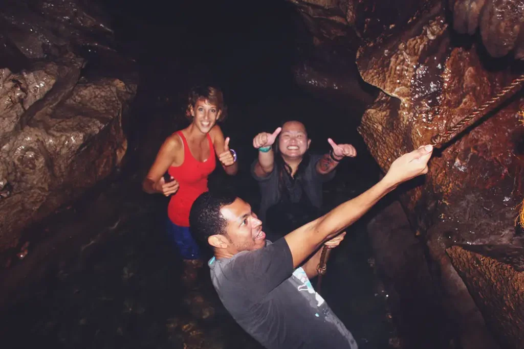 Stef y Xopau me animan mientras trato de escalar una roca usando una soga.