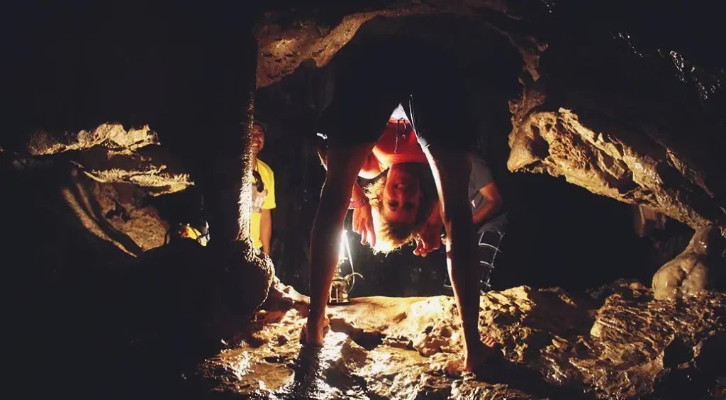 Stef posa para la cámara en medio de un cruce oscuro dentro de la cueva.