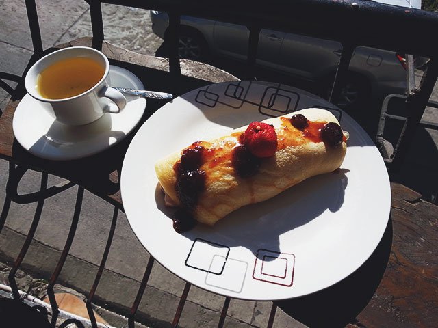 Un desayuno de té y un yogurt pancake sobre un asoleado balcón en Sagada.