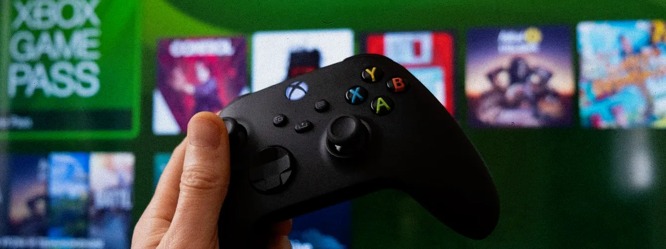 Control de Xbox frente a una pantalla que muestra el logo de Xbox Game Pass
